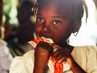Haitian girl eating peanut paste